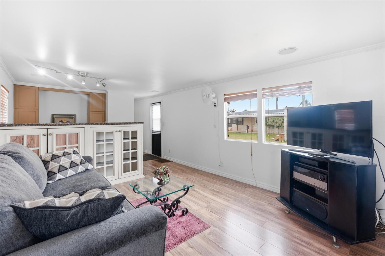 A living room features a grey sofa, a glass coffee table, and a television stand — 12375 S Military Trail # 188, Boynton Beach FL 33436, BOYNTON BEACH, FL