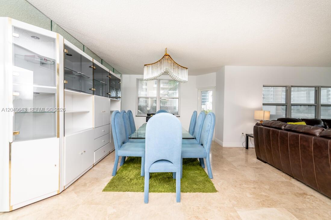 A dining room features a glass table, blue upholstered chairs, and a large white cabinet — 1985 S Ocean Dr # 2Q, Hallandale Beach FL 33009, HALLANDALE BEACH, FL