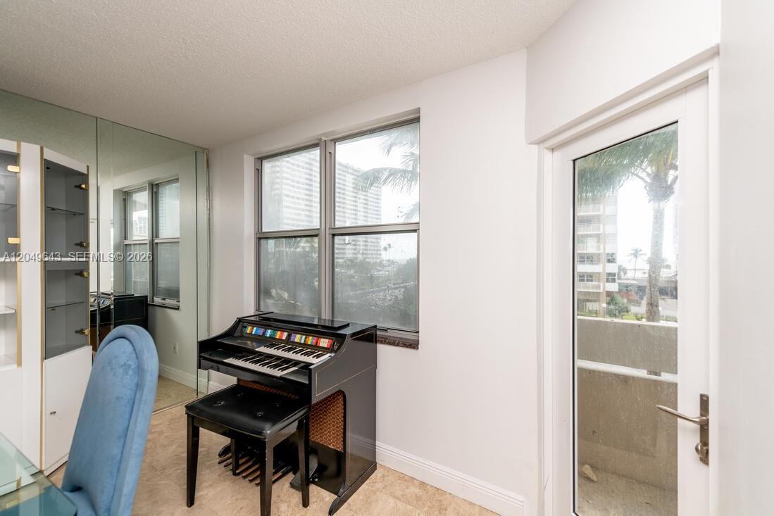 A room with a black organ, tiled floors, mirrored walls, and a glass door — 1985 S Ocean Dr # 2Q, Hallandale Beach FL 33009, HALLANDALE BEACH, FL
