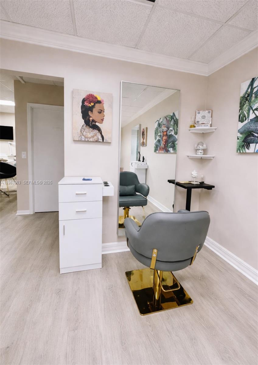 A salon station features a grey chair, a large mirror, and a white storage cabinet — 2100 E Hallandale Beach Blvd, Hallandale Beach FL 33009, HALLANDALE BEACH, FL