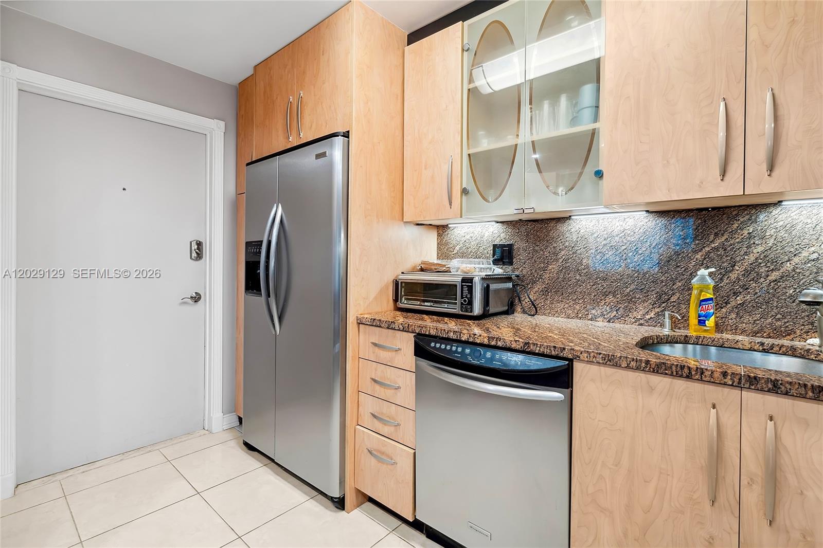 A kitchen features light wood cabinets, stainless steel appliances, and a brown granite countertop — 1400 S Ocean Dr # 802, Hollywood FL 33019, HOLLYWOOD, FL