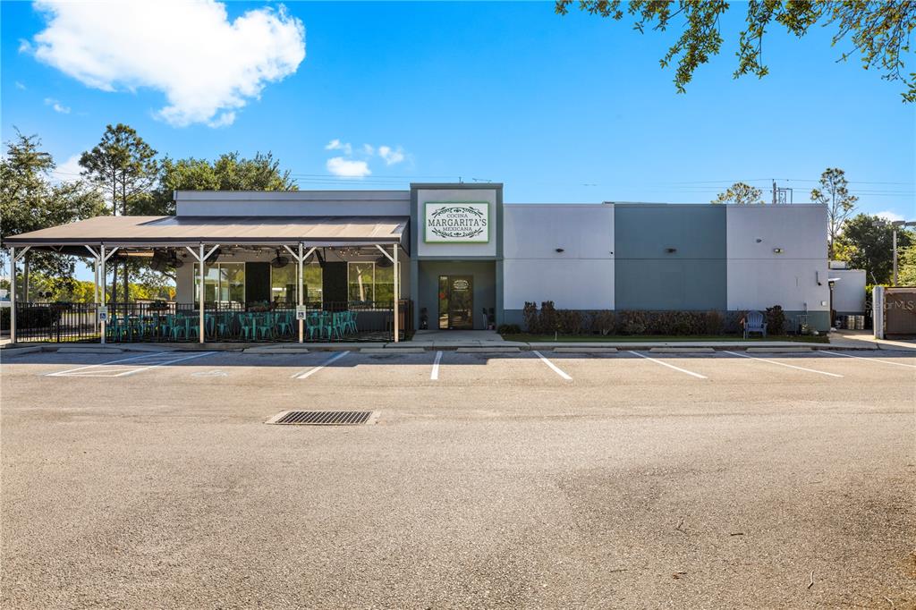 A single-story commercial building with a covered outdoor patio and a parking lot in front — 7350 CYPRESS GARDENS BOULEVARD, WINTER HAVEN, FL