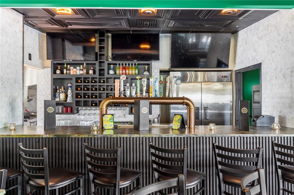 A bar area features a dark corrugated counter, black chairs, and a metal beer tap system — 7350 CYPRESS GARDENS BOULEVARD, WINTER HAVEN, FL