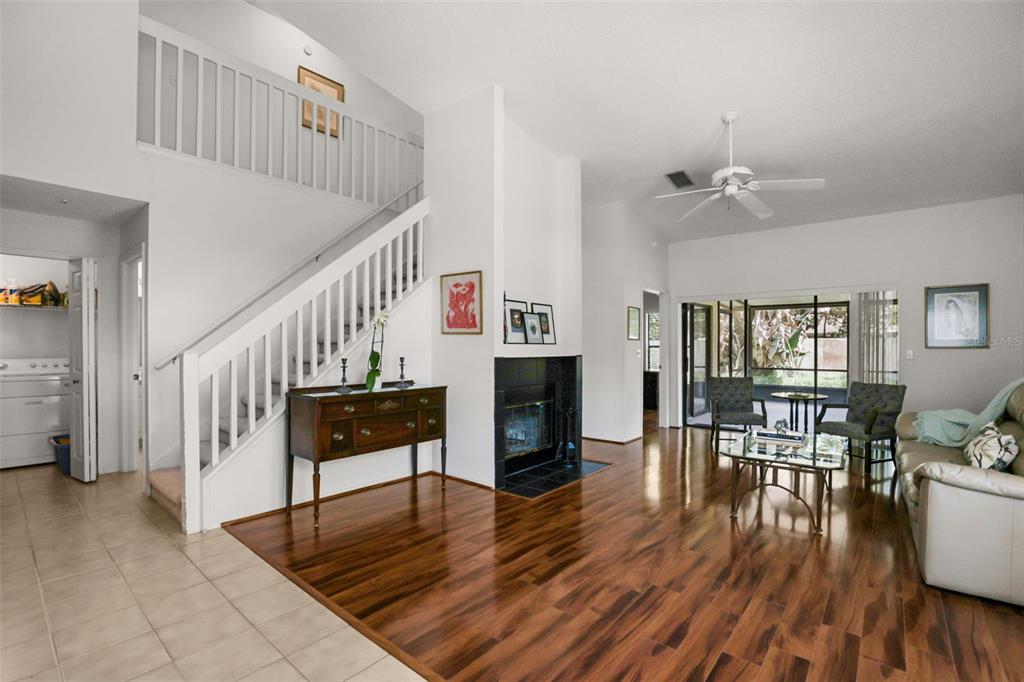 A living room features hardwood floors, a fireplace, a staircase, and a sliding glass door — 223 HERON STREET, ALTAMONTE SPRINGS, FL