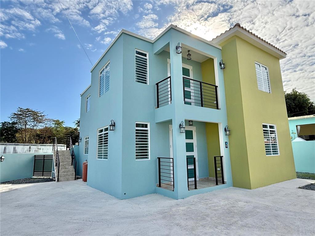 A two-story house with blue and green exterior walls features balconies and outdoor staircases — Carr 115 km 8.7 CALLE HOSTOS, RINCON, PR