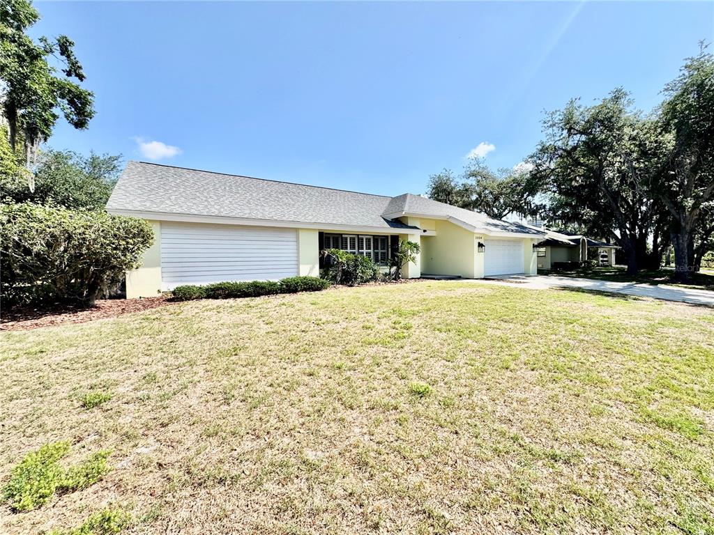 A single-story house with a light yellow exterior, a gray roof, and two garage doors — 2804 WEDGEWOOD DRIVE, PLANT CITY, FL