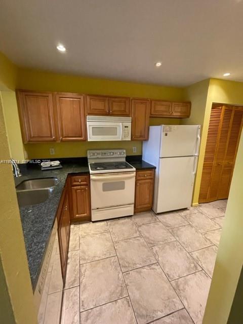 A kitchen features wood cabinets, a white stove, a white refrigerator, and tiled flooring — 20815 NE 8th Ct # 20, Miami FL 33179, MIAMI, FL