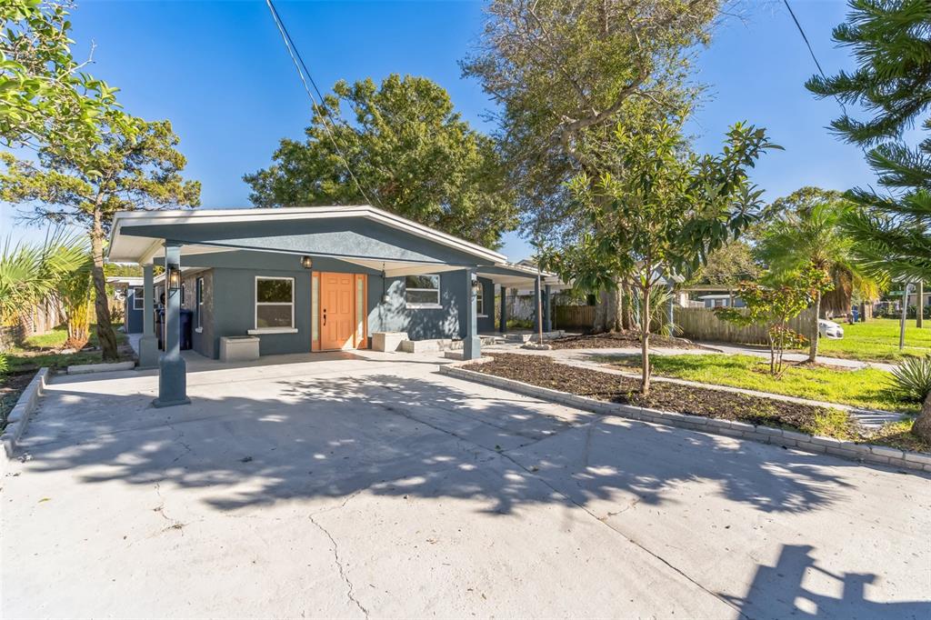 A blue single-story house with a concrete driveway and a covered front porch — 5210 S 84TH STREET, TAMPA, FL