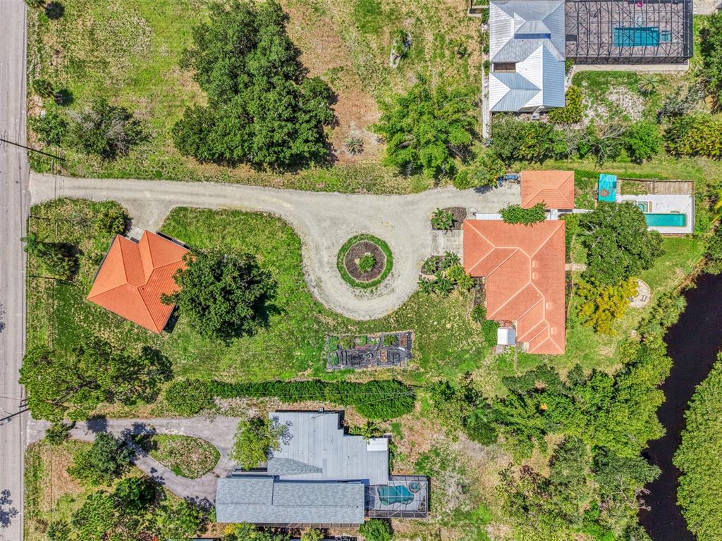An aerial view shows two houses with orange roofs, a circular driveway, and a swimming pool — 140 S OXFORD DRIVE, ENGLEWOOD, FL