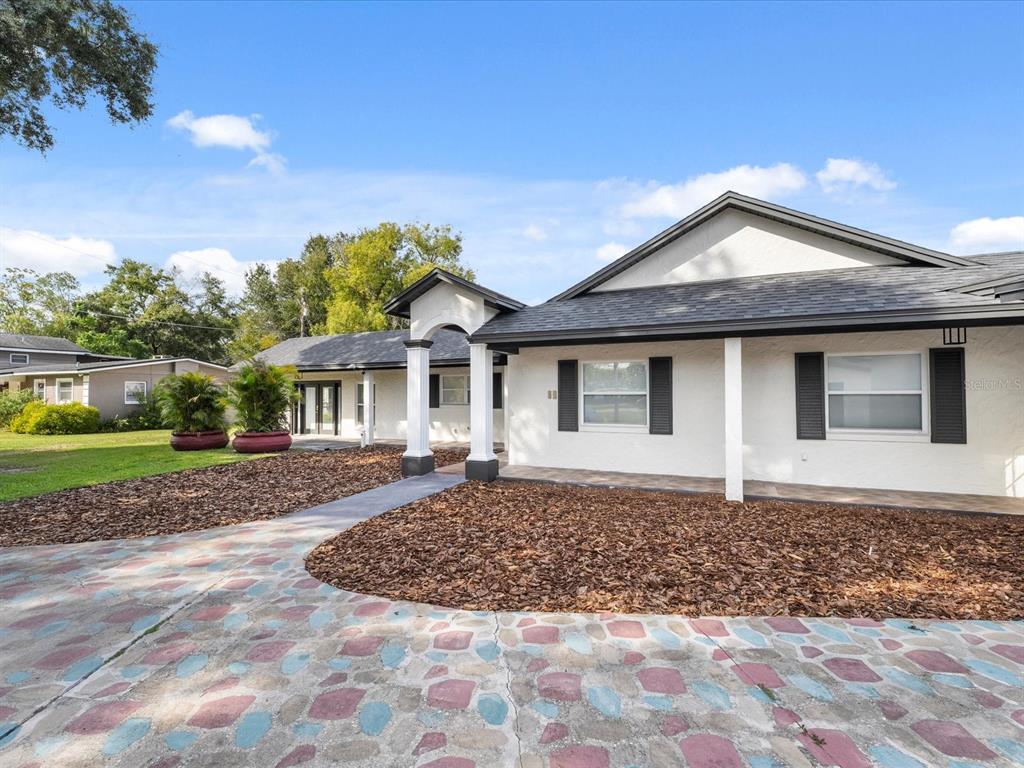 A white house with a dark roof and a multicolored stone driveway — 329 SEMINOLA BOULEVARD, CASSELBERRY, FL