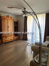 A living room features a large wooden cabinet, a floor lamp, and a glass-topped table — 3606 S Ocean Blvd # 504, Highland Beach FL 33487, HIGHLAND BEACH, FL