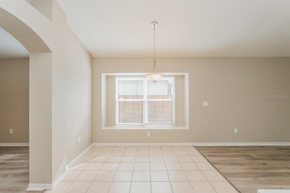 A dining area features beige walls, a tile floor, and a window with blinds — 411 SAND RIDGE DRIVE, VALRICO, FL