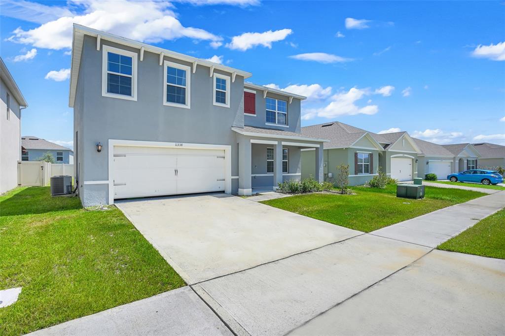 A two-story gray house with a two-car garage and a concrete driveway — 11338 AMBER RIDGE DRIVE, ZELLWOOD, FL