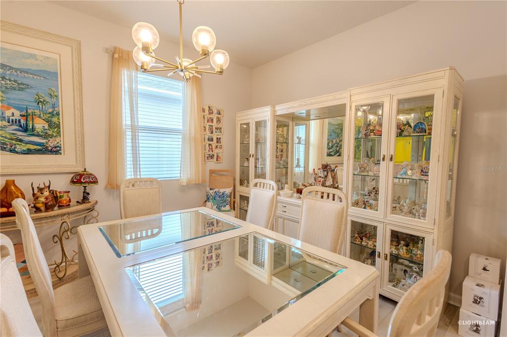 A dining room features a glass-topped table, white chairs, and a large matching china cabinet — 10297 CHURCH HAMMOCK ROAD, LEESBURG, FL