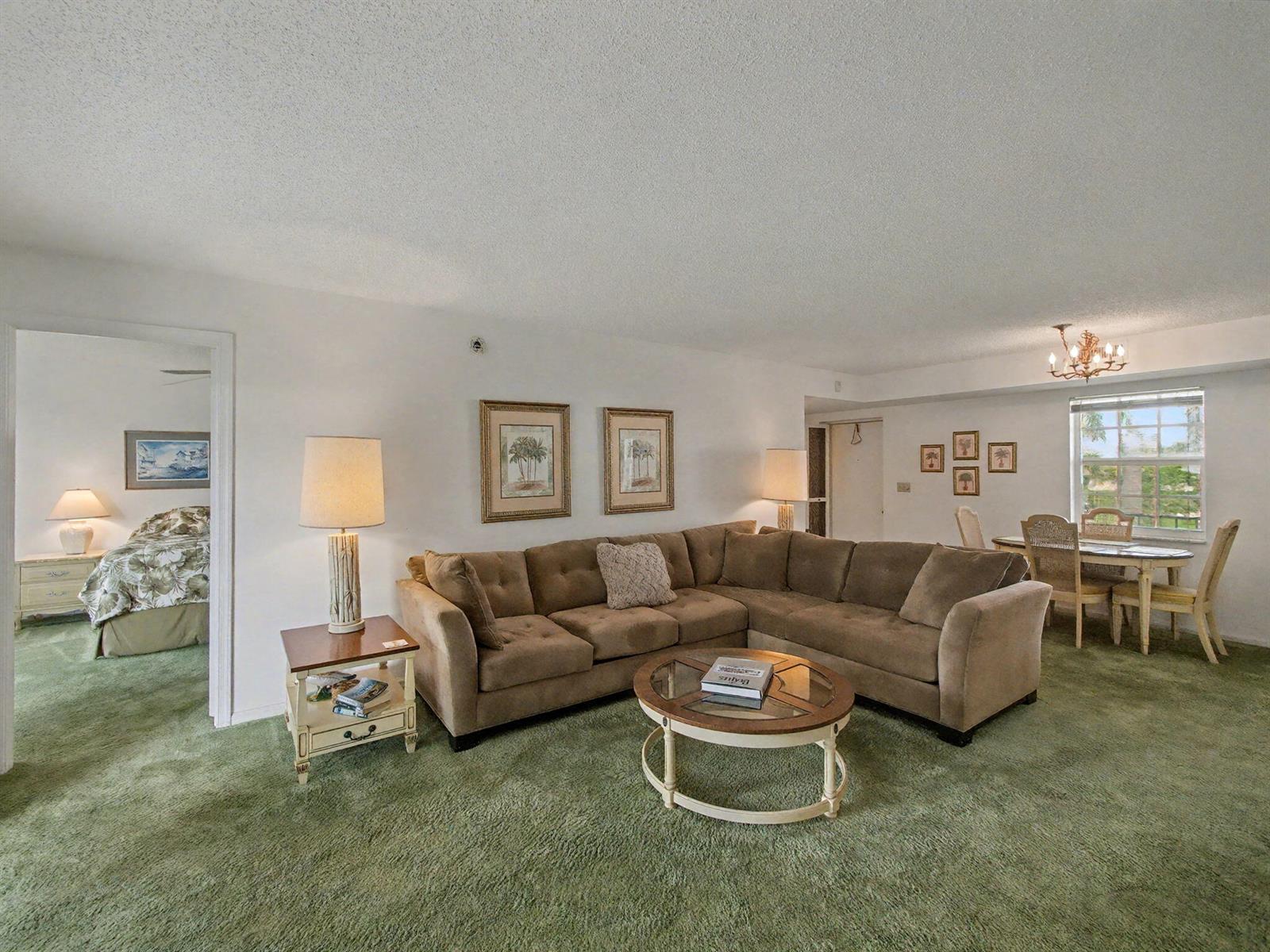 A living room with a brown sectional sofa, round coffee table, and green wall-to-wall carpeting — 1205 Sandy Lane # 246, Singer Island FL 33404, SINGER ISLAND, FL