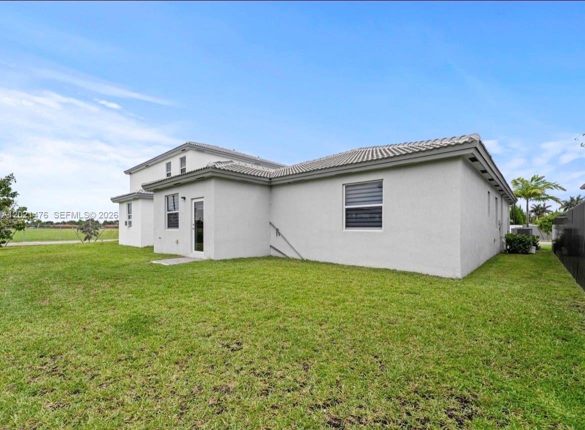 The exterior view shows the back of a two-story house with a grassy yard — 14884 SW 162nd St, Miami FL 33187, MIAMI, FL
