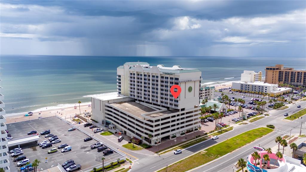 An aerial view shows a large beachfront hotel with an attached parking garage — 2700 N ATLANTIC AVENUE UNIT 821, DAYTONA BEACH, FL