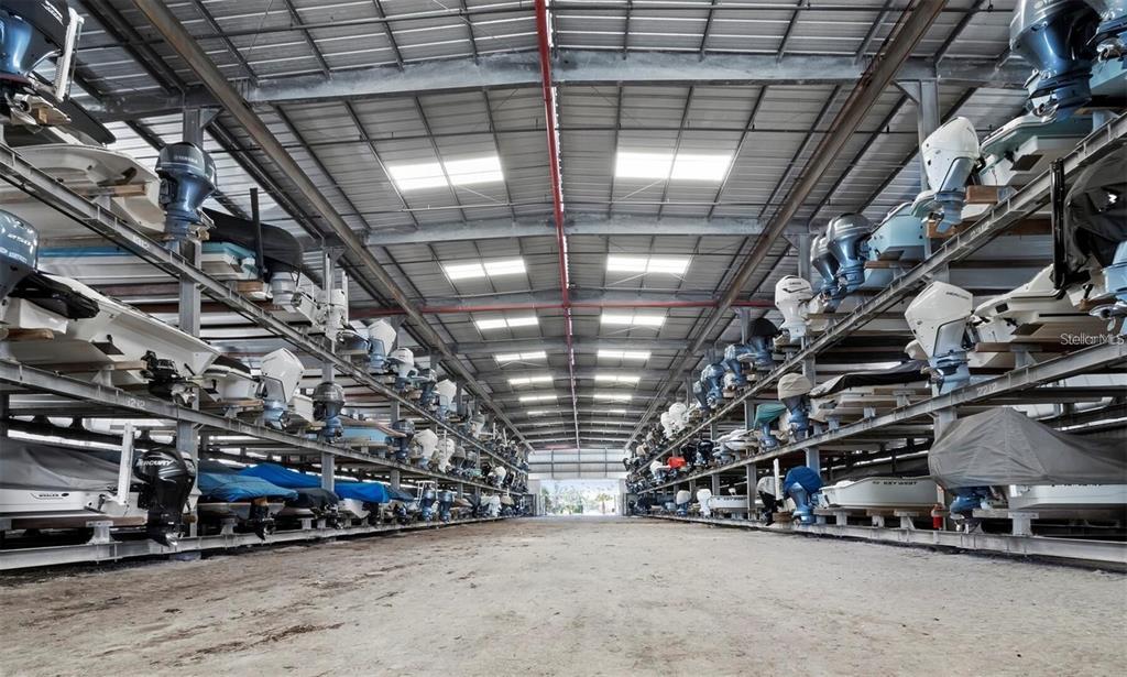A large indoor boat storage facility with multiple levels of racks holding numerous boats — 408 GULF OF MEXICO DRIVE UNIT 2126, LONGBOAT KEY, FL