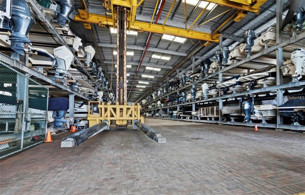 A large indoor boat storage facility features stacked racks holding numerous boats under a metal roof — 408 GULF OF MEXICO DRIVE UNIT 2126, LONGBOAT KEY, FL