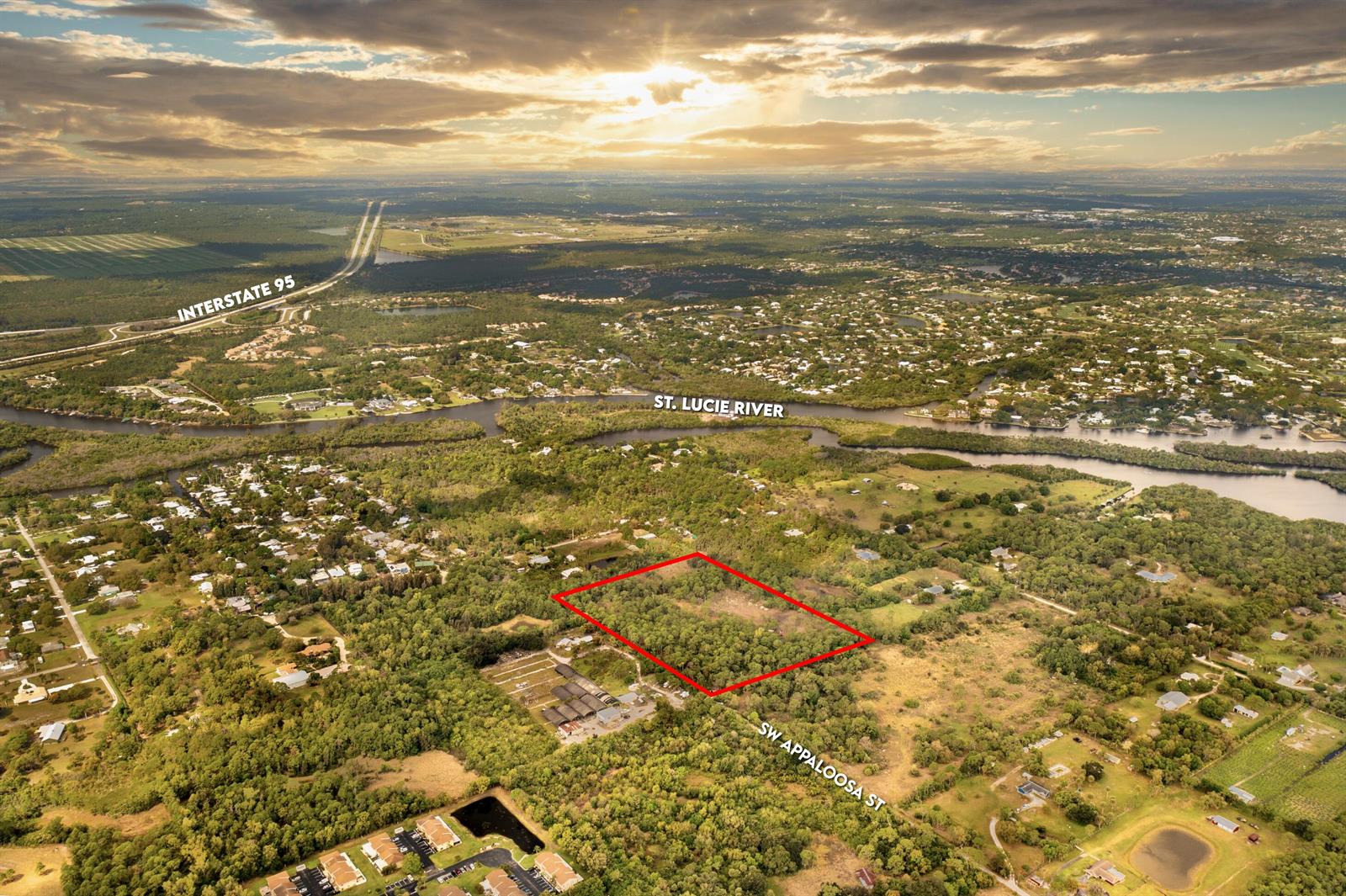 An aerial view shows a rectangular plot of land outlined in red near a river — 223 SW Appaloosa Street, Stuart FL 34997, STUART, FL