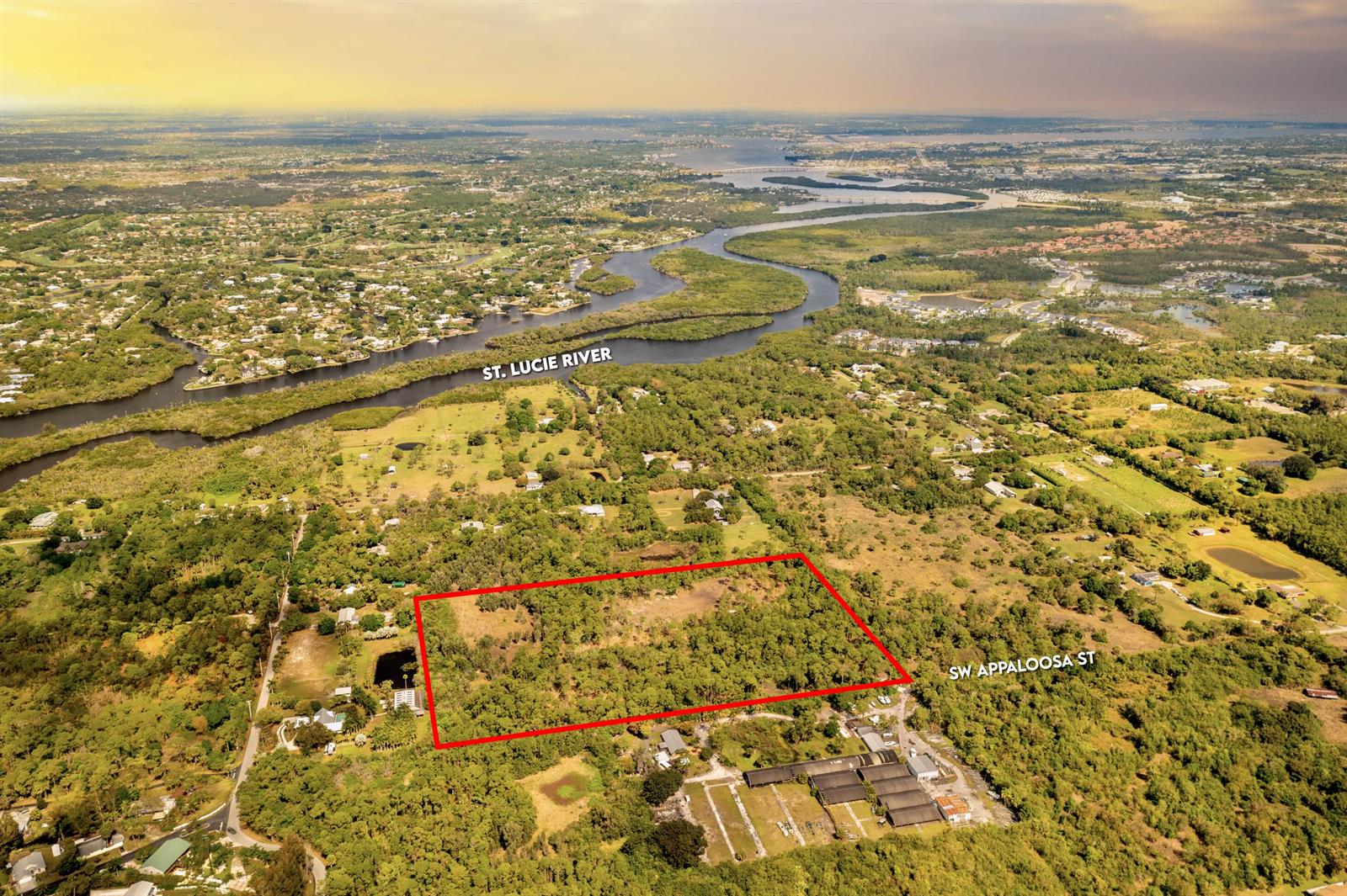 An aerial view shows a rectangular plot of land outlined in red near a river — 223 SW Appaloosa Street, Stuart FL 34997, STUART, FL