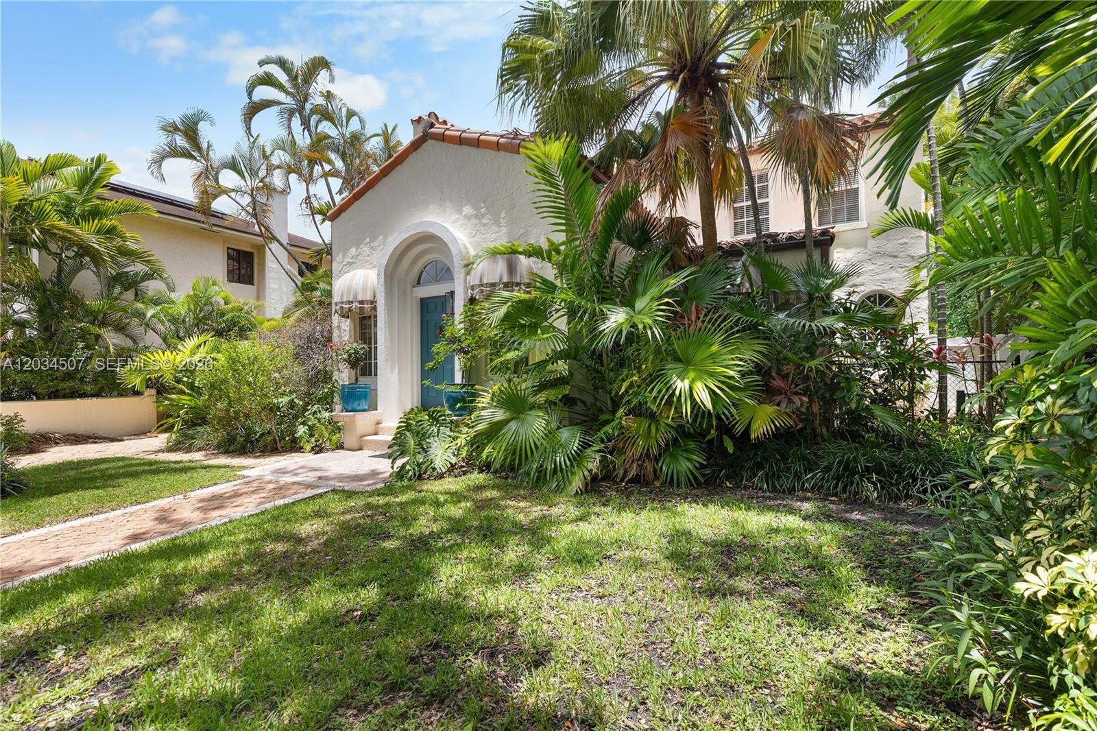 A stucco house with a blue front door and arched entryway is surrounded by palm trees — 1511 SW 13th St, Miami FL 33145, MIAMI, FL
