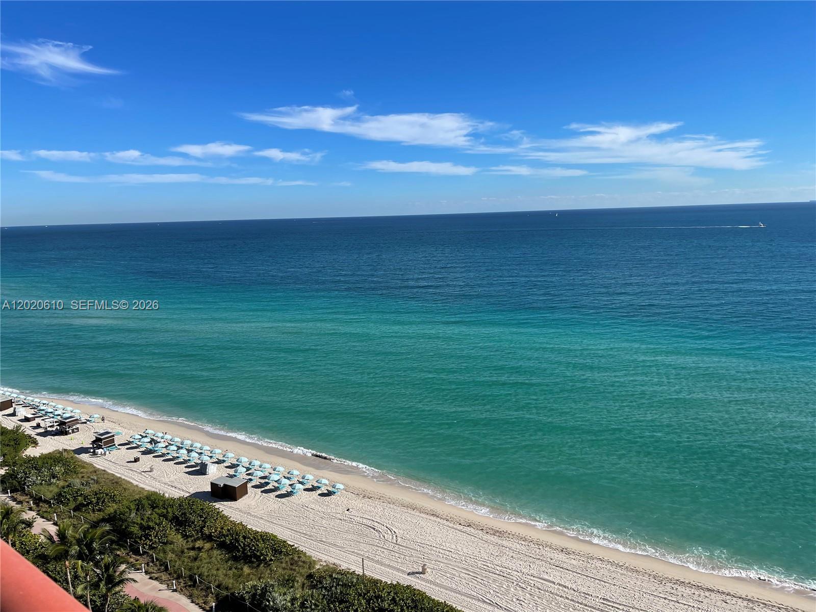 An elevated view of a sandy beach with rows of umbrellas along the oceanfront — MIAMI BEACH, FL
