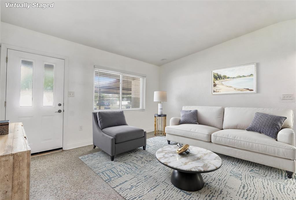 A living room features a white sofa, a gray armchair, and a marble coffee table — 6601 HARVEY STREET, ORLANDO, FL