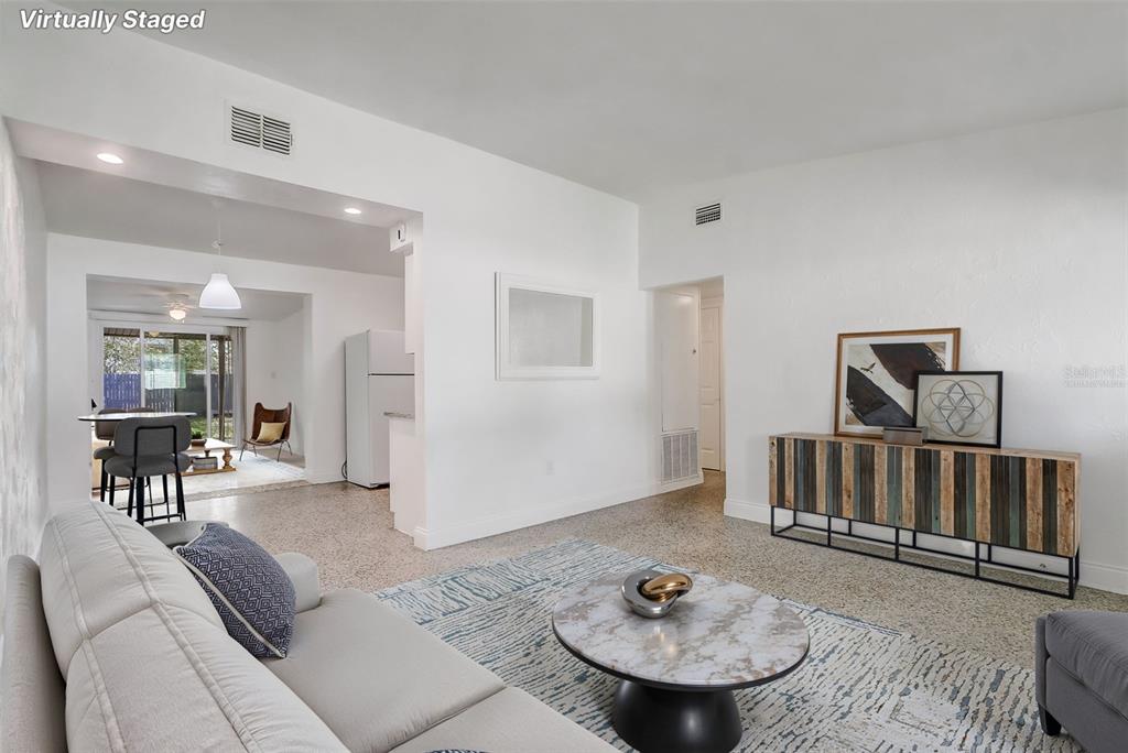 A living room with a white sofa, marble coffee table, and a wooden sideboard — 6601 HARVEY STREET, ORLANDO, FL