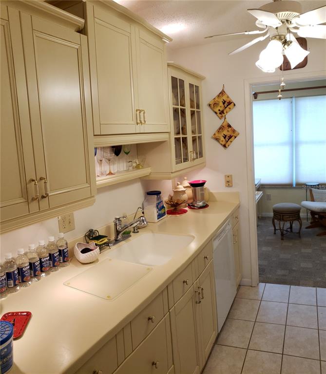 A living room features light-colored carpet, a decorative desk, and a mix of traditional furniture — 5935 30TH AVENUE S UNIT 307, GULFPORT, FL
