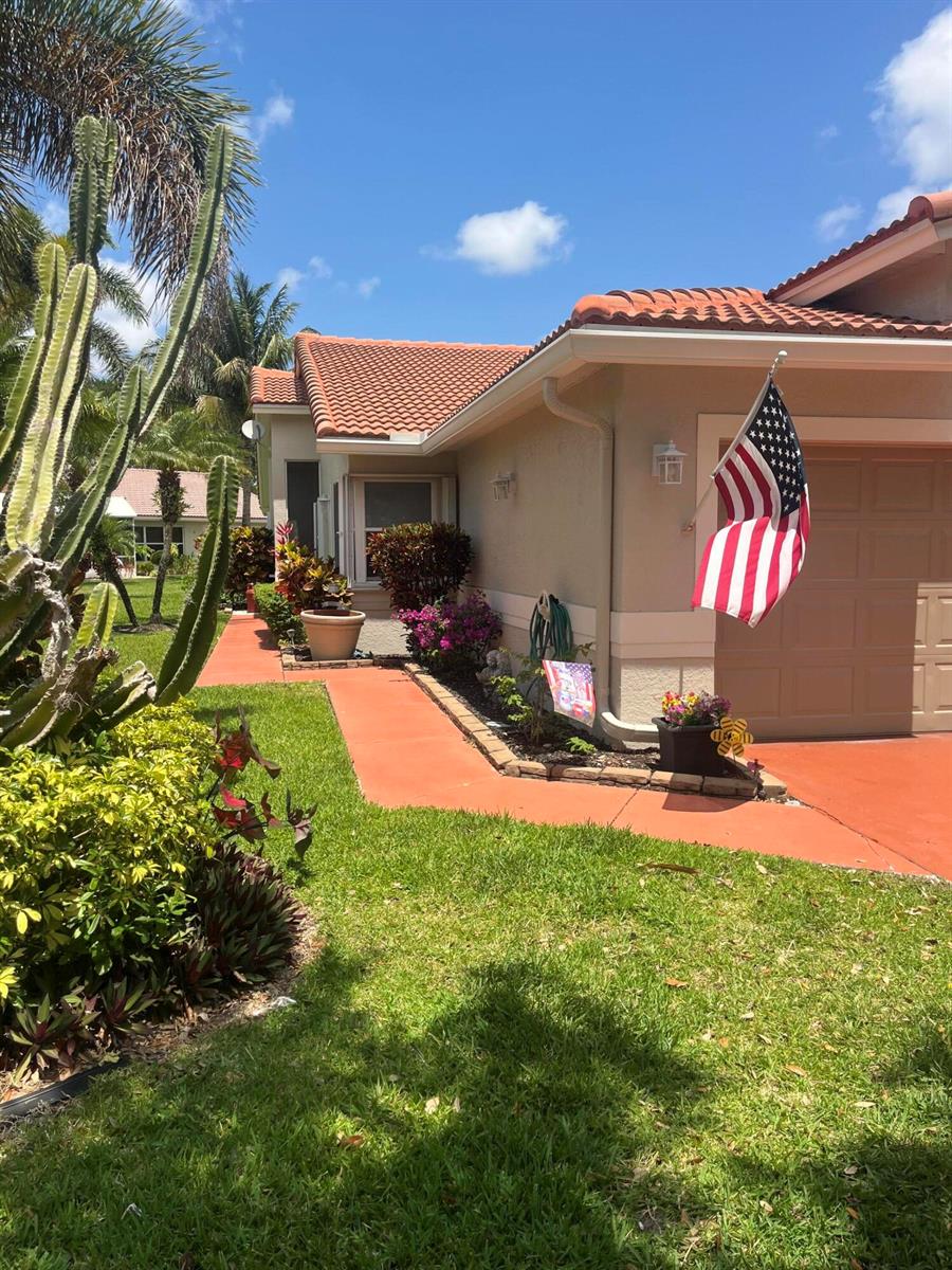 A single-story house with a terracotta roof, tan stucco walls, and a red walkway — 96 Sausalito Circle, Boynton Beach FL 33436, BOYNTON BEACH, FL