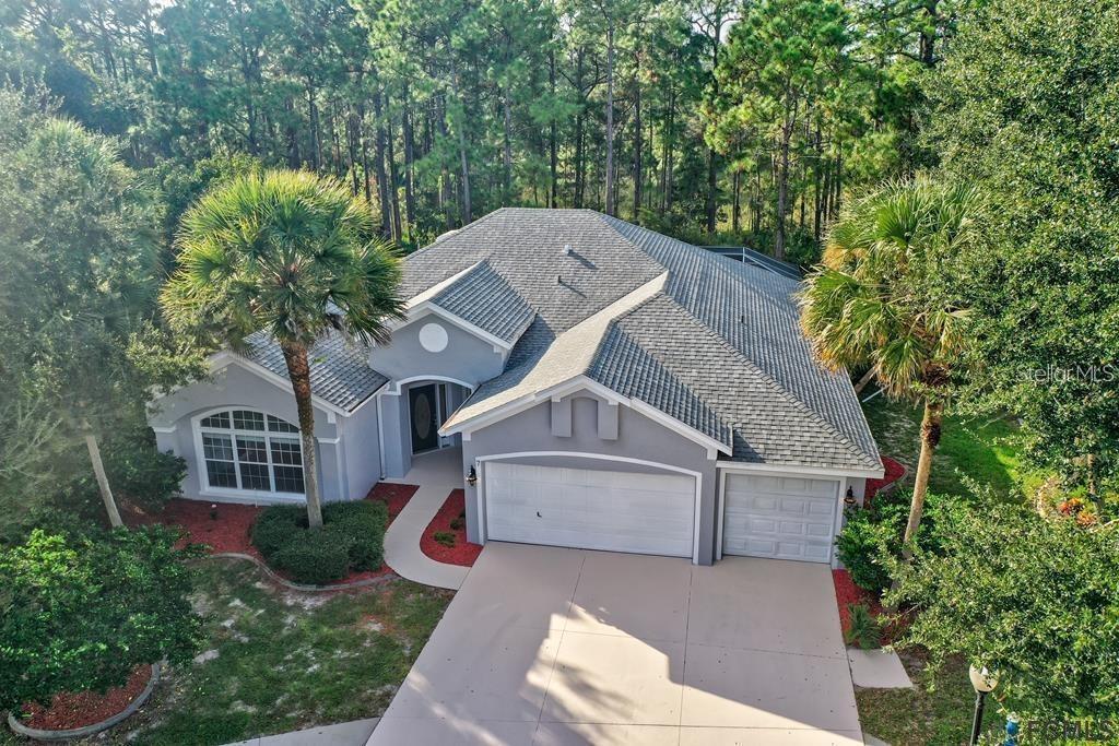 An aerial view of a gray single-story house with a three-car garage and palm trees — 7 SHINNECOCK COURT, PALM COAST, FL