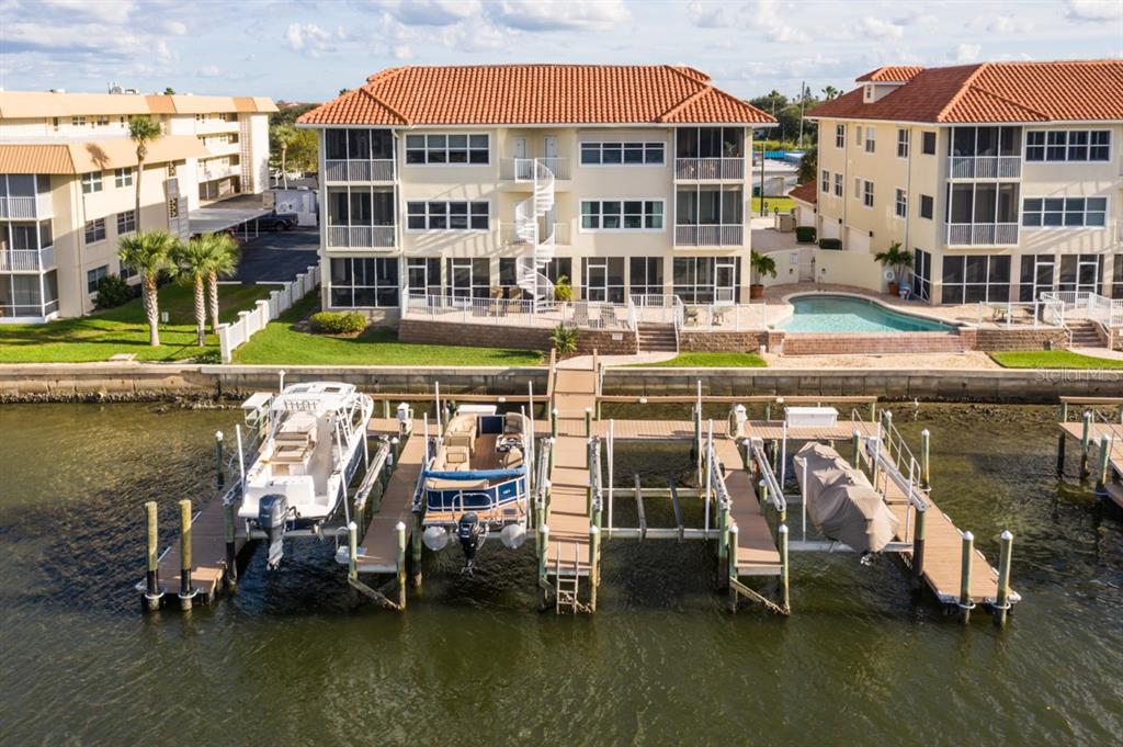 An aerial view of a waterfront condominium building with a private dock and boat slips — 273 MIDDLE WAY UNIT G, NEW SMYRNA BEACH, FL
