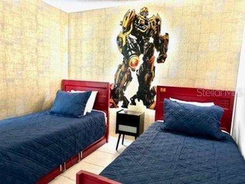 A bedroom features two twin beds with blue quilts and a large Bumblebee wall decal — 50989 HIGHWAY 27 UNIT 333, DAVENPORT, FL