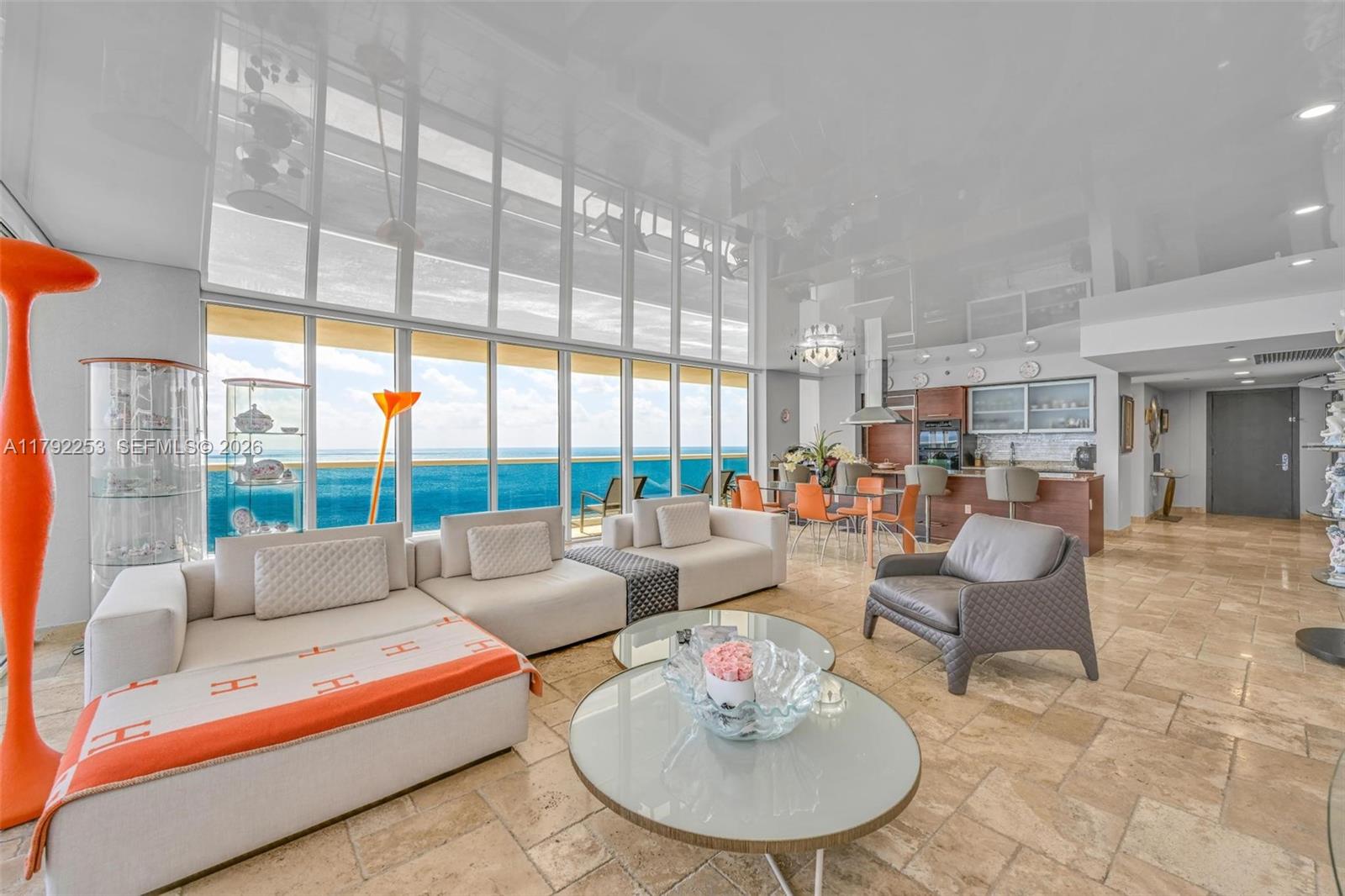 A modern living room with floor-to-ceiling windows overlooking the ocean and a glossy ceiling — 1830 S Ocean Dr # 1201, Hallandale Beach FL 33009, HALLANDALE BEACH, FL