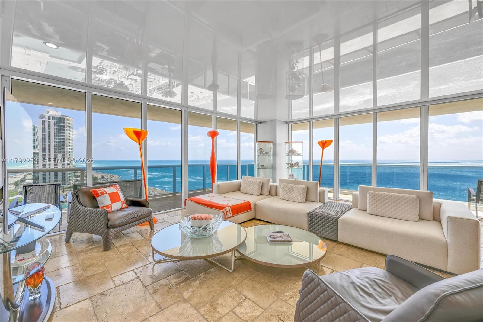 A modern living room features floor-to-ceiling windows with ocean views and a glossy white ceiling — 1830 S Ocean Dr # 1201, Hallandale Beach FL 33009, HALLANDALE BEACH, FL