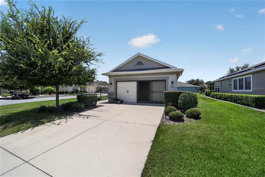A single-story house with a concrete driveway, a garage, and a manicured lawn — 9440 SW 98TH TERRACE, OCALA, FL
