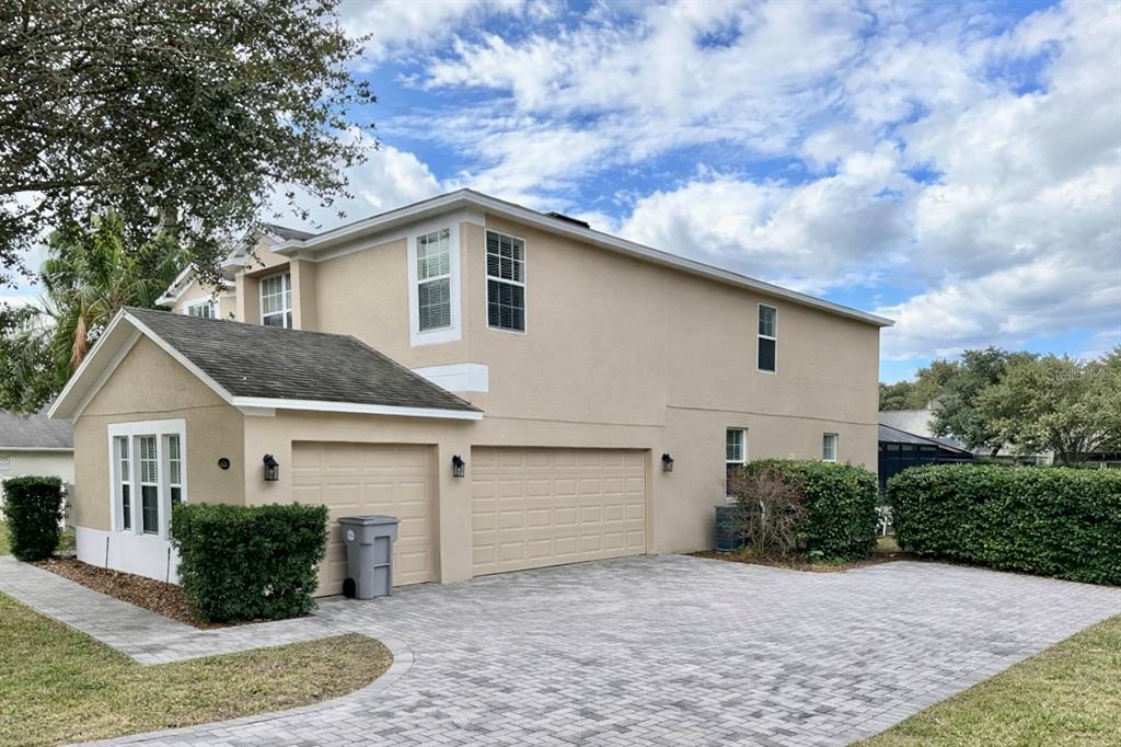 A two-story house with a three-car garage and a paved driveway under a cloudy sky — 4410 PINE GOLD AVENUE, APOPKA, FL