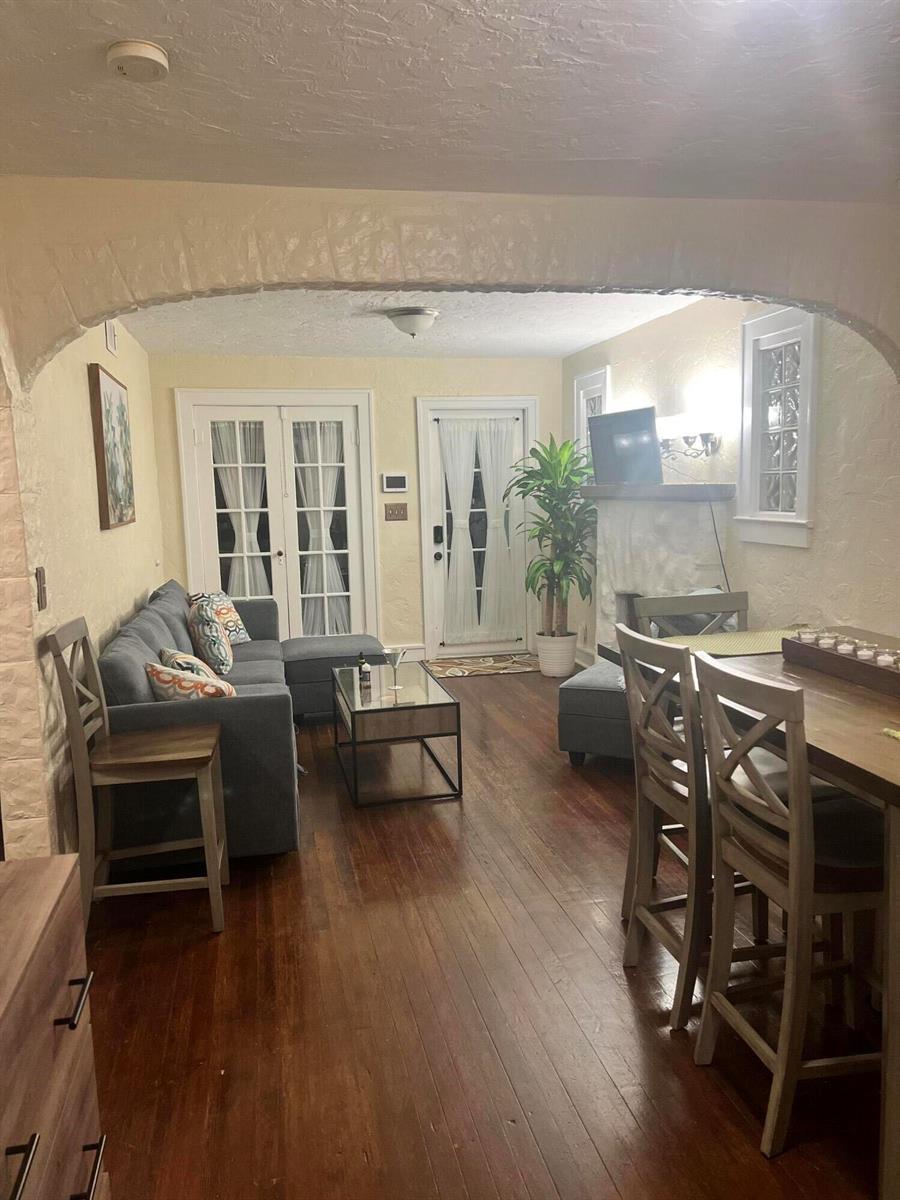 A living and dining area features an arched entryway, hardwood floors, and a gray sofa — 314 S L Street, FL 33460, FL