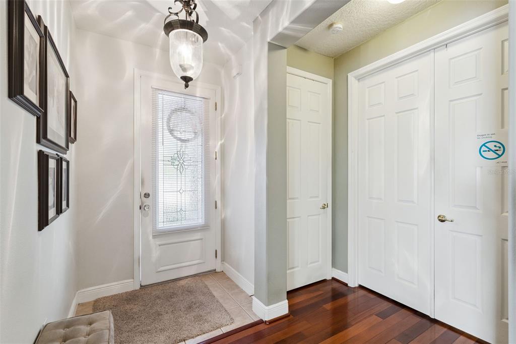 An entryway features a front door with a glass insert, tile flooring, and hardwood floors — 116 GLENDALE COURT, KISSIMMEE, FL