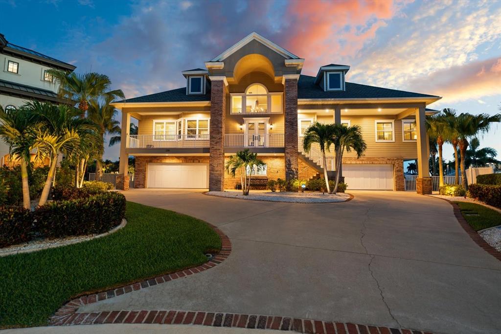 A two-story house with a raised main level, brick pillars, and a concrete driveway — 226 POINCIANA LANE, LARGO, FL