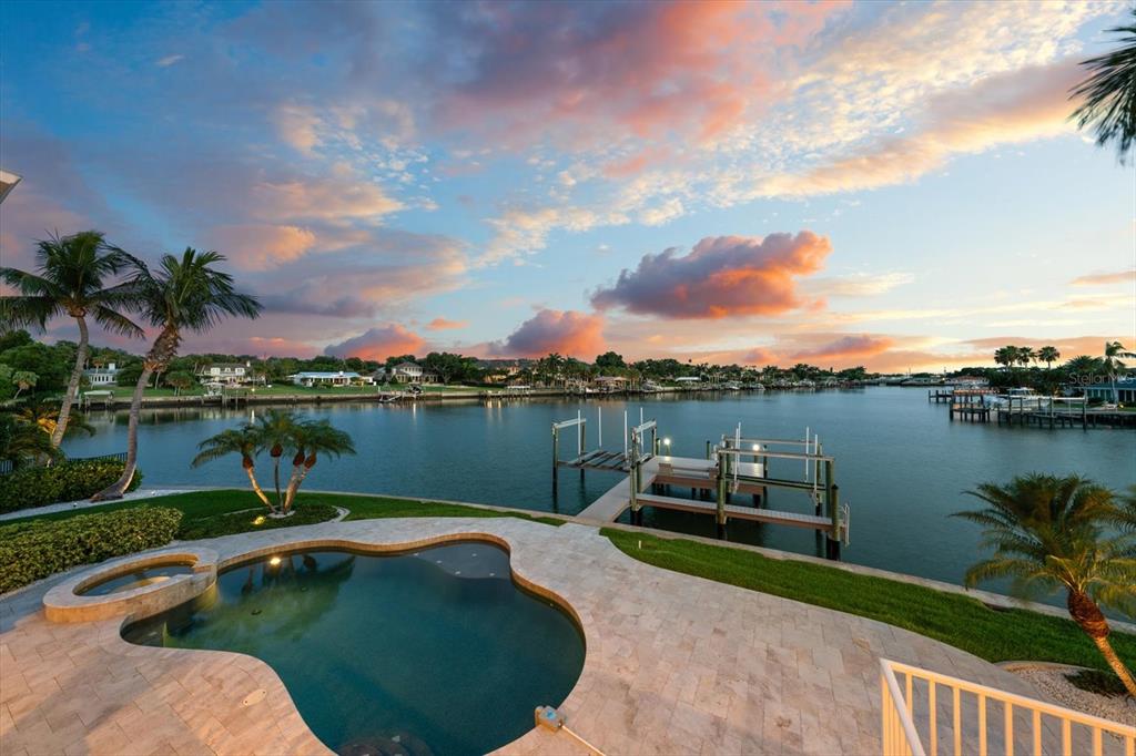 A swimming pool and private dock overlook a calm waterway at sunset — 226 POINCIANA LANE, LARGO, FL