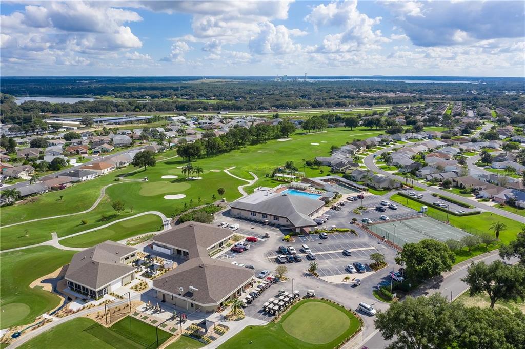 An aerial view shows a community clubhouse with a pool, tennis courts, and golf course — 5987 TEAL TRAIL, LAKELAND, FL