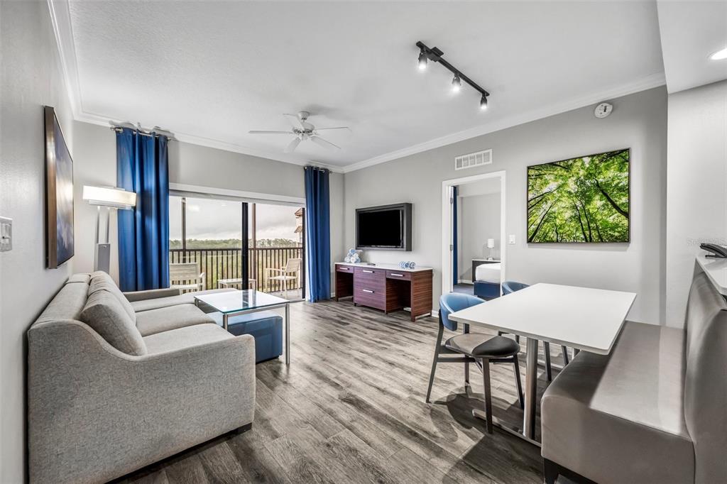 A living room features a gray sofa, dining area, and sliding glass doors to a balcony — 14501 GROVE RESORT AVENUE UNIT 1703, WINTER GARDEN, FL