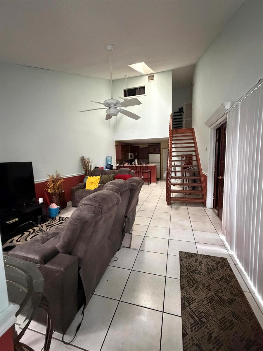An empty bedroom features orange walls, white tile flooring, and a ceiling fan — 2035 Winners Circle, North Lauderdale FL 33068, NORTH LAUDERDALE, FL