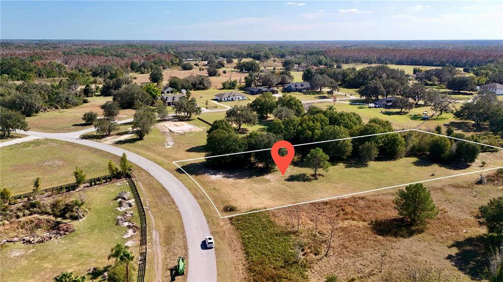 An aerial view shows a vacant, grassy lot outlined in white with a red location pin — GREENGROVE BOULEVARD, CLERMONT, FL