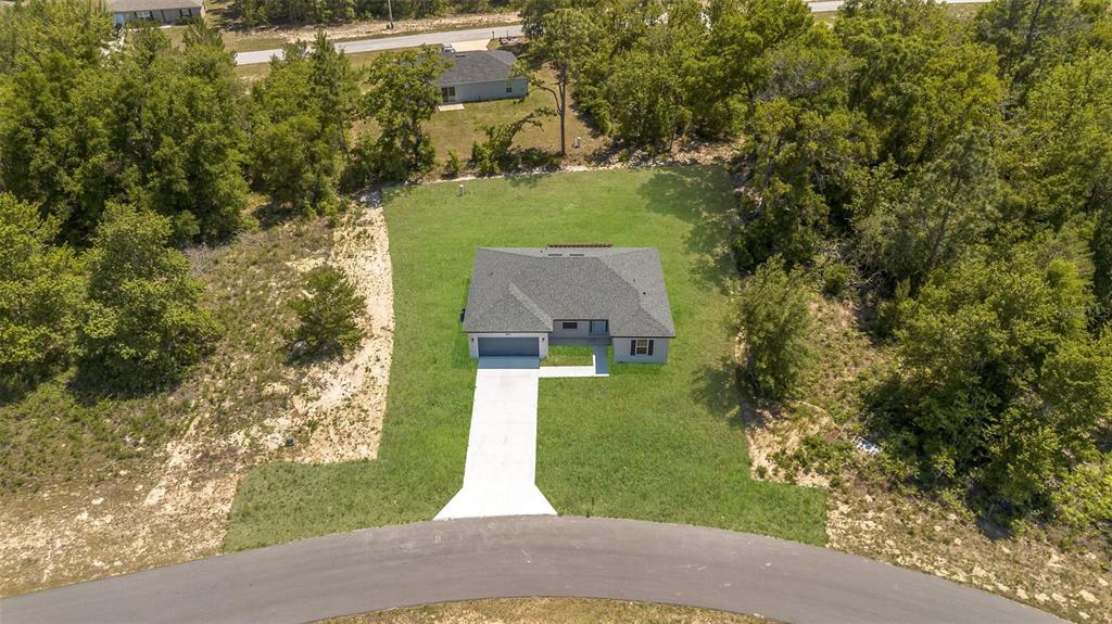 An aerial view shows a single-story house with a gray roof centered on a grassy lot — 2386 SW 168TH LOOP, OCALA, FL