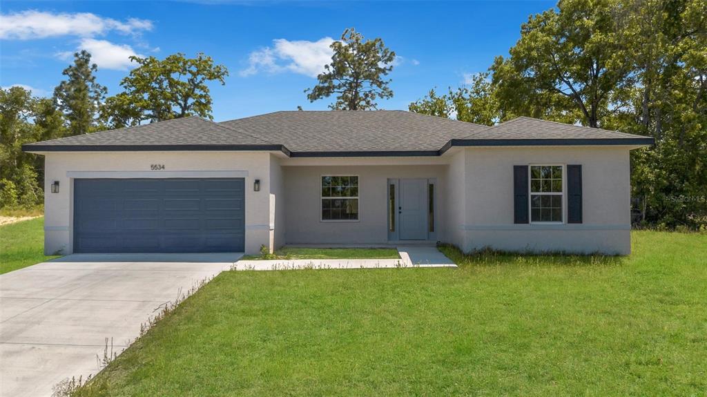 A single-story house with a gray garage, light-colored stucco exterior, and a front lawn — 2386 SW 168TH LOOP, OCALA, FL