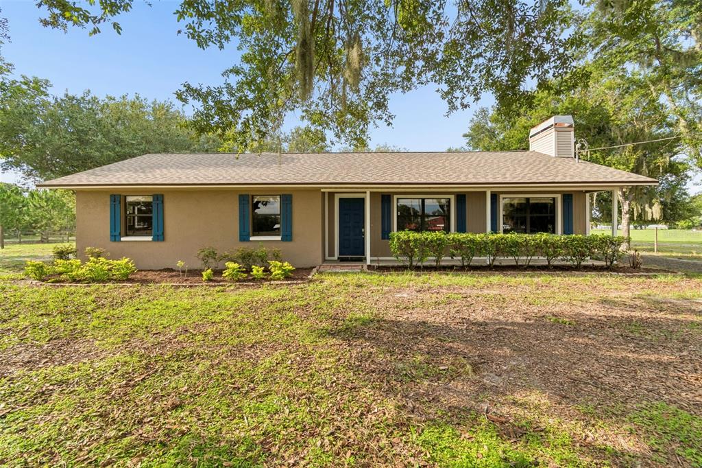 A single-story house with a brown exterior, blue shutters, and a front porch — 336 CORBETT ROAD, LITHIA, FL