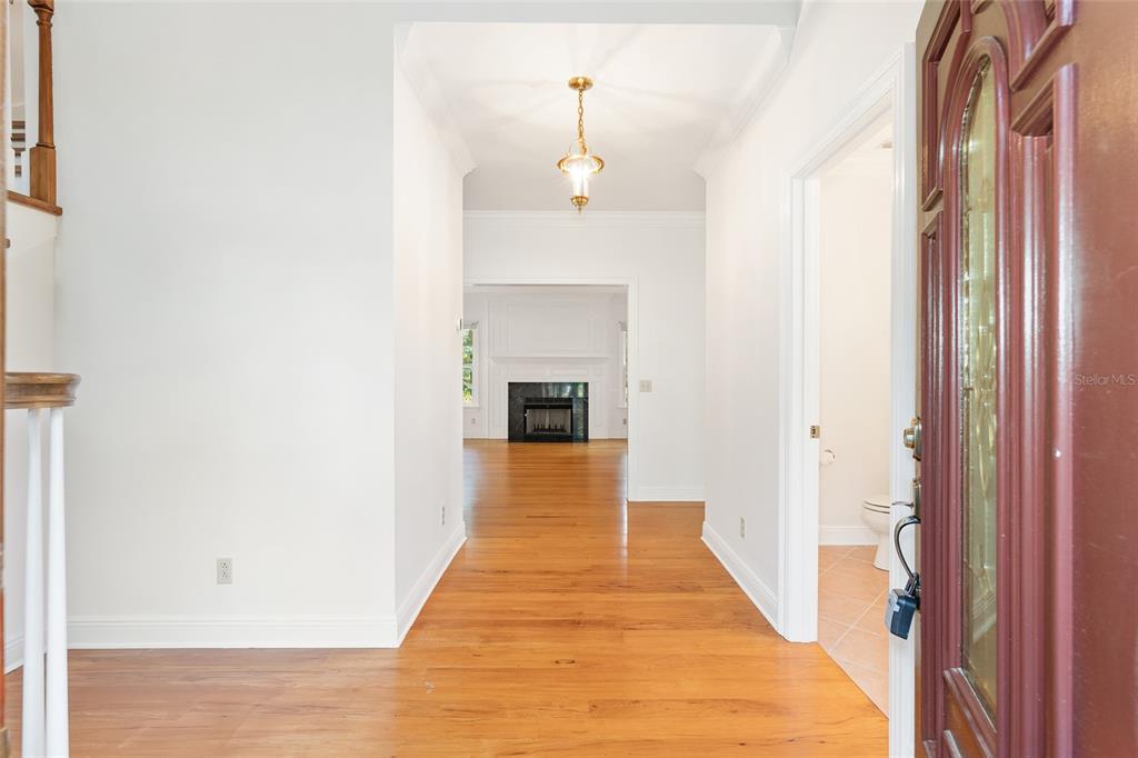 A foyer with hardwood floors leads to a living room with a fireplace — 6581 S MAGNOLIA AVENUE, OCALA, FL